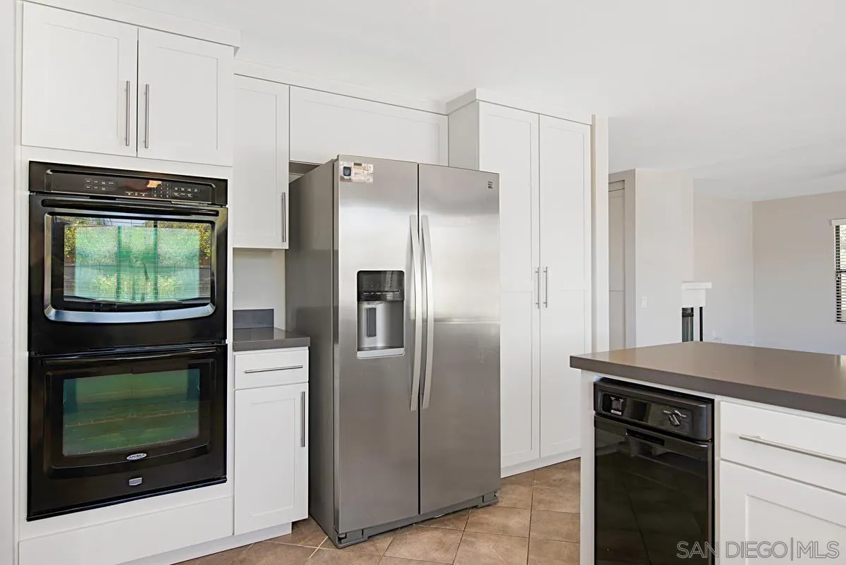 4031 Grayson Drive San Diego, CA 92130 - Photo 12 of 40 a kitchen with stainless steel appliances granite countertop a refrigerator and a stove top oven