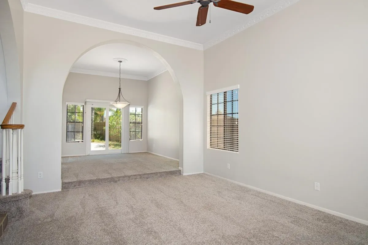 4031 Grayson Drive San Diego, CA 92130 - Photo 6 of 40 an empty room with chandelier fan and windows