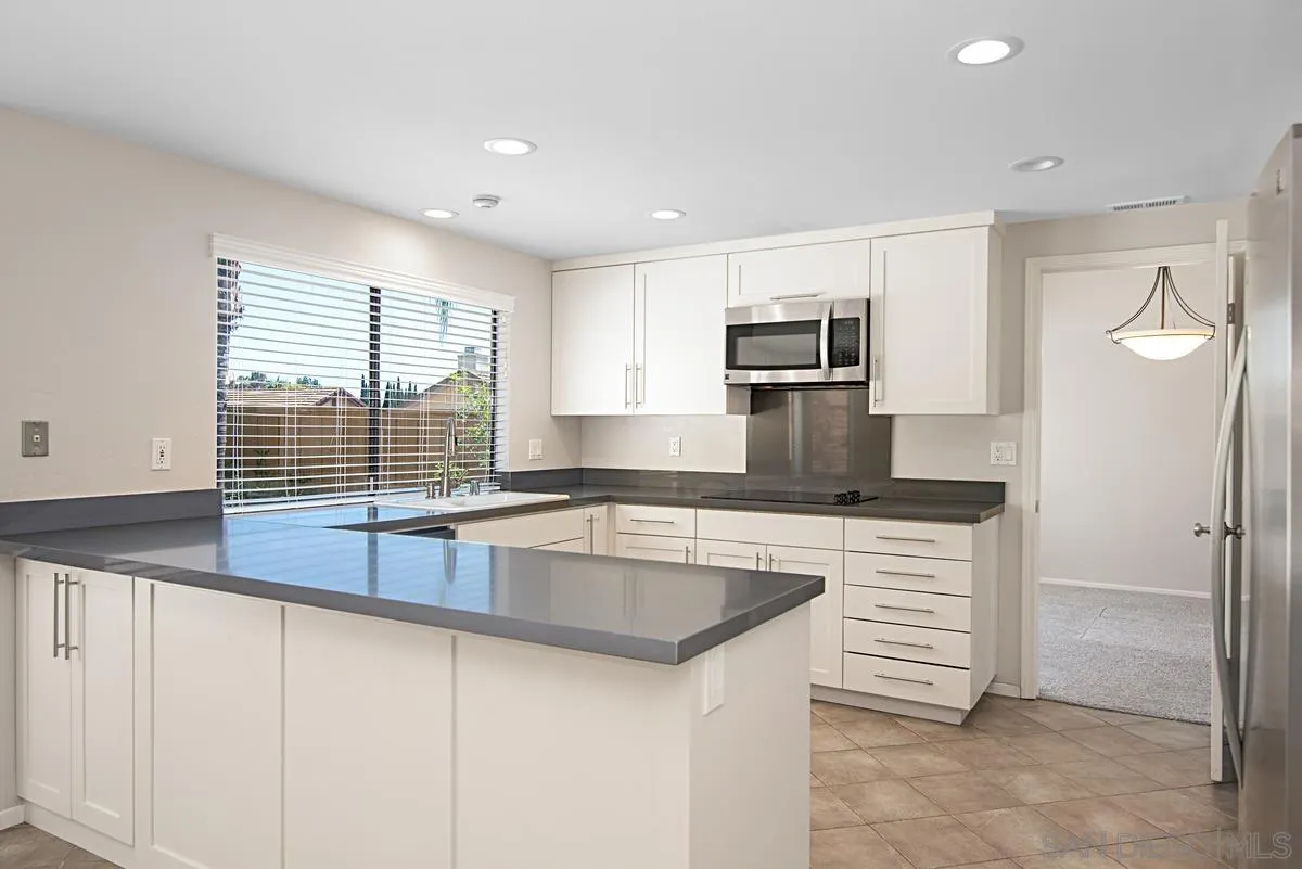 4031 Grayson Drive San Diego, CA 92130 - Photo 10 of 40 a kitchen with stainless steel appliances granite countertop a sink and a stove