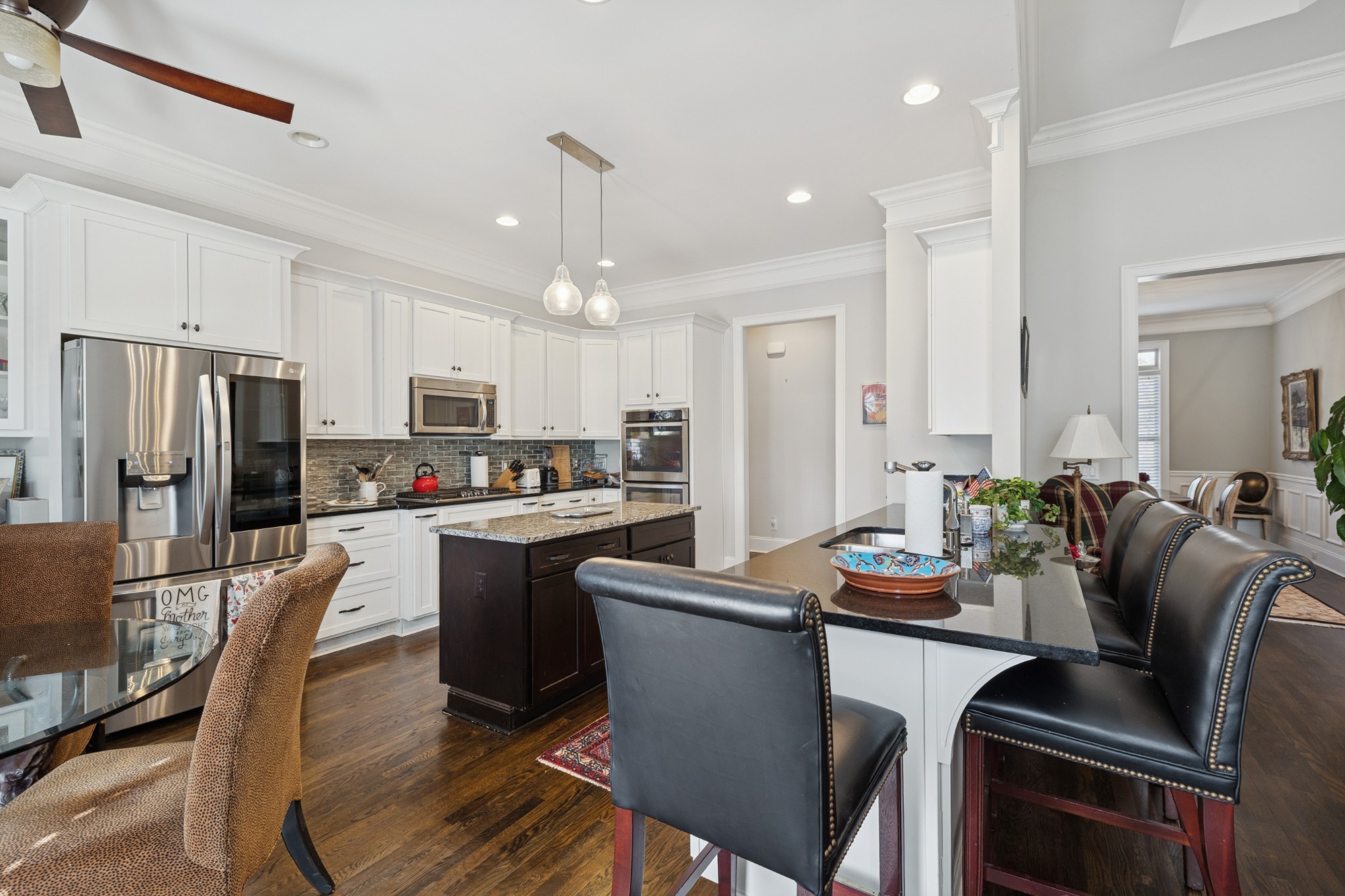 6400 Harding Pike Nashville, TN 37205 - Photo 13 of 38 a kitchen with kitchen island a dining table cabinets appliances and a refrigerator