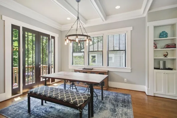 a dining room with wooden floor wooden floor and a chandelier