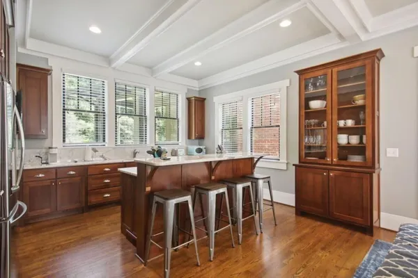 a kitchen with stainless steel appliances granite countertop wooden floors and wooden cabinets