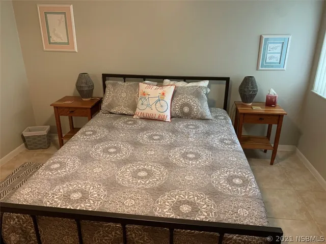 a view of a bedroom with wooden floor and chair
