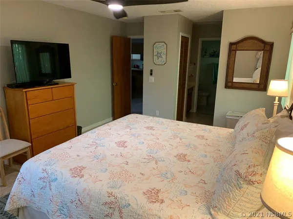 a bedroom with a bed and a flat screen tv