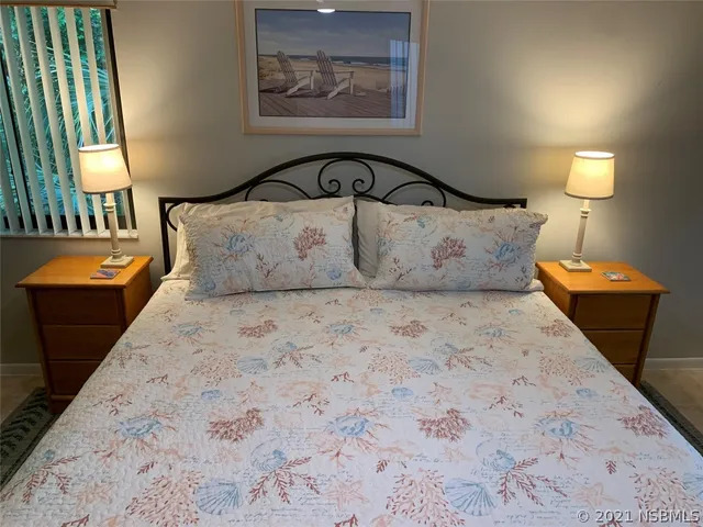 a large bed sitting in a bedroom next to a lamp