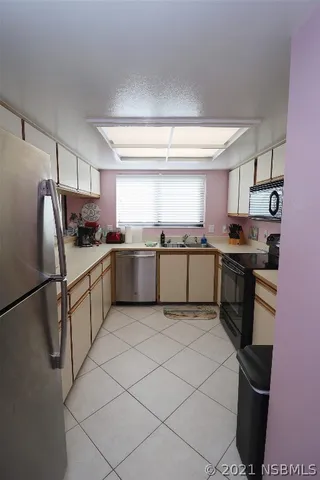 a kitchen with stainless steel appliances granite countertop a refrigerator sink and stove