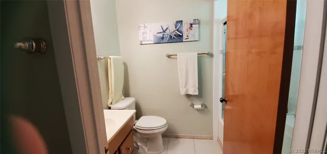 a white toilet sitting next to a bathroom sink and vanity