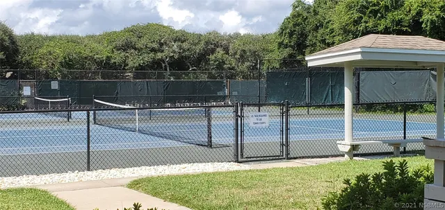 a view of a tennis court with a fence