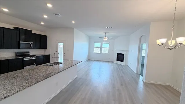 a large kitchen with sink refrigerator and cabinets