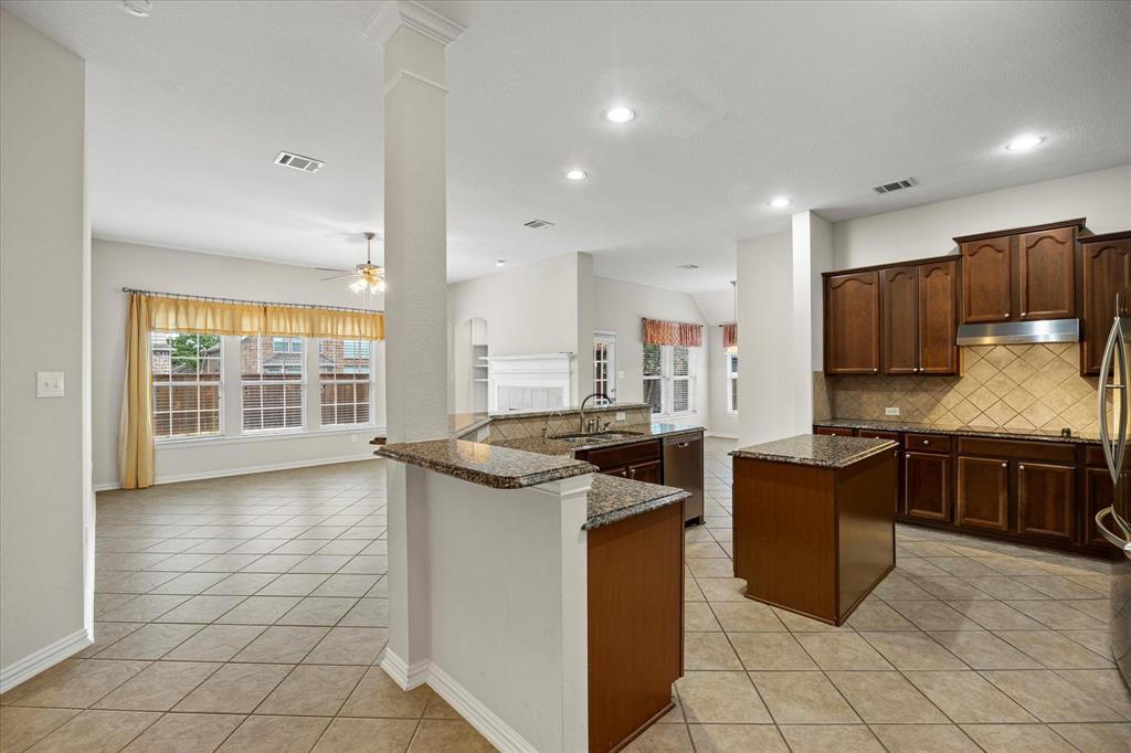 207 Leonard Way Fate, TX 75087 - Photo 12 of 31 a kitchen with stainless steel appliances granite countertop a stove top oven a sink a counter top space and cabinets