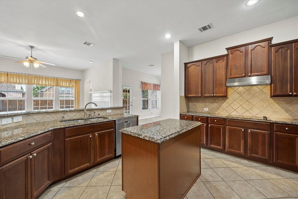 207 Leonard Way Fate, TX 75087 - Photo 13 of 31 a kitchen with stainless steel appliances granite countertop a sink counter space cabinets and a large window