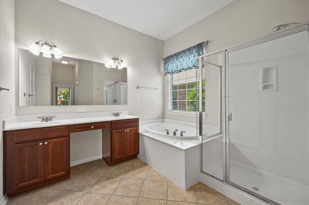 207 Leonard Way Fate, TX 75087 - Photo 5 of 31 a bathroom with a sink vanity tub shower and a mirror
