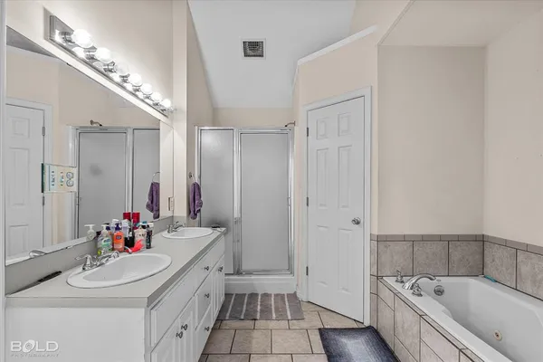 a bathroom with a tub sink and mirror