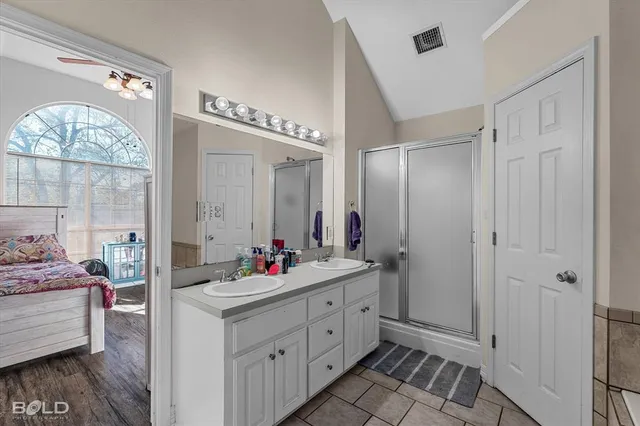 a bathroom with a double vanity sink mirror and shower