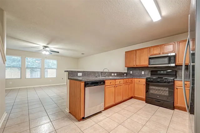 a kitchen with stainless steel appliances granite countertop a stove and a sink