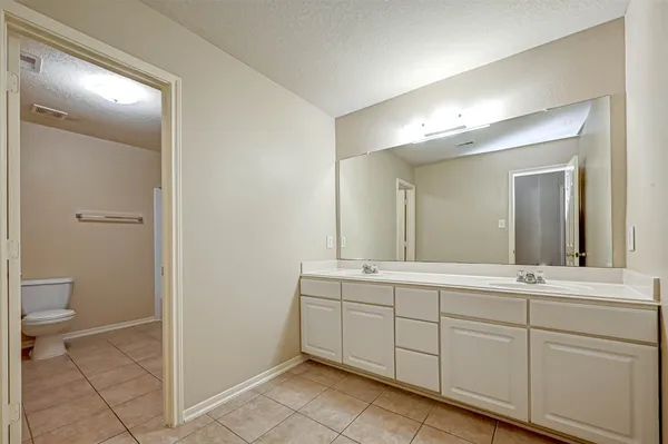 a spacious bathroom with a toilet sink and a mirror