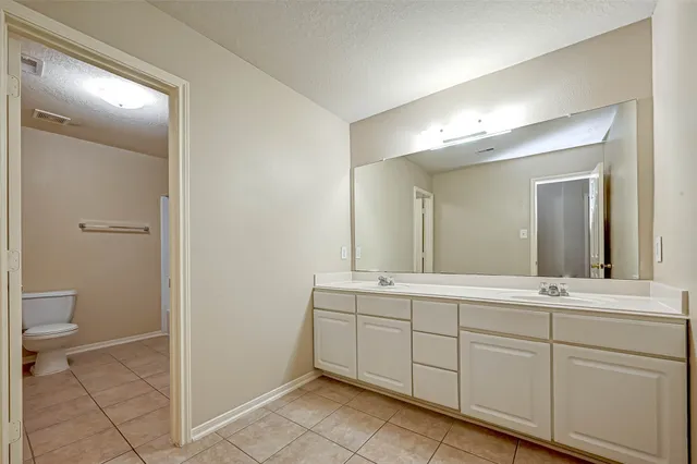a spacious bathroom with a toilet sink and a mirror