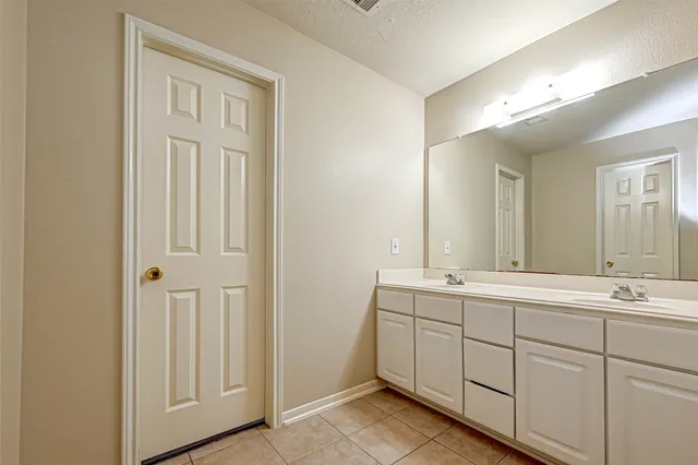 a bathroom with a double vanity sink and mirror