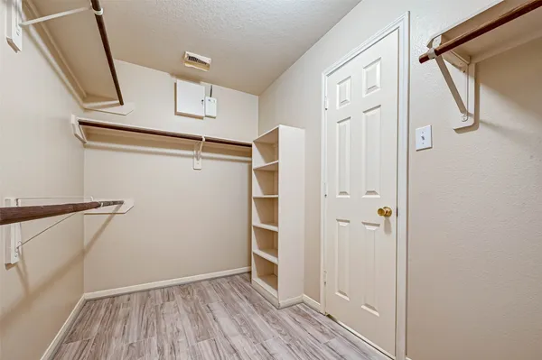 a view of walk in closet with empty racks