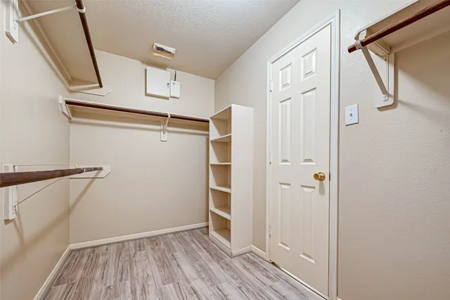a view of walk in closet with empty racks