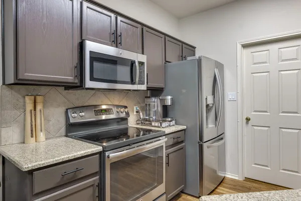 a kitchen with stainless steel appliances granite countertop a stove and a refrigerator