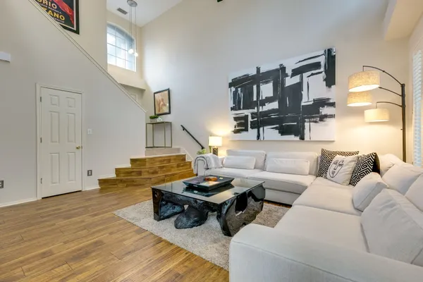 a living room with furniture floor to ceiling window and a flat screen tv