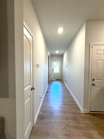 a view of a hallway with wooden floor