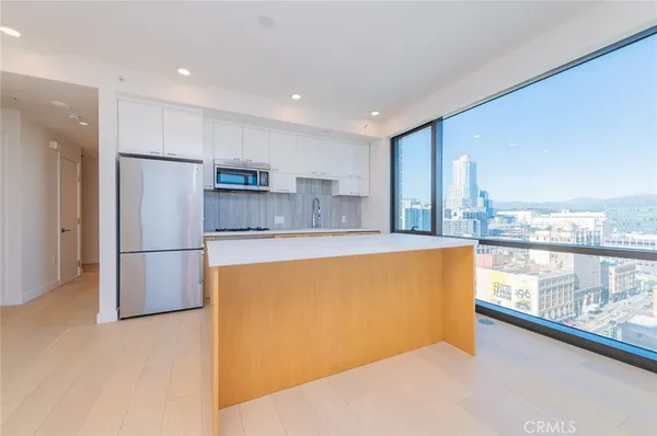 a view of a kitchen with kitchen island a sink a stove and a refrigerator