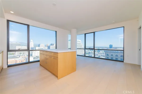 a large kitchen with stainless steel appliances granite countertop a large counter top a sink and a refrigerator