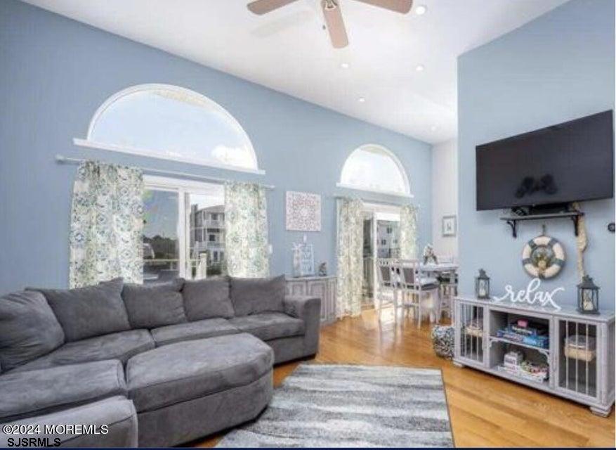 113 Marlin Road Tuckerton, NJ 08087 - Photo 3 of 14 a living room with furniture a flat screen tv and a floor to ceiling window