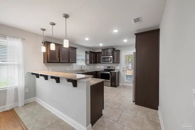 a kitchen with stainless steel appliances granite countertop a sink stove and microwave