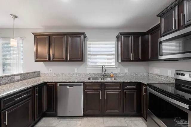a kitchen with stainless steel appliances granite countertop a stove microwave and sink