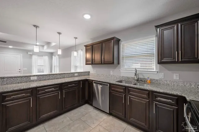 a kitchen with stainless steel appliances granite countertop wooden cabinets and a sink