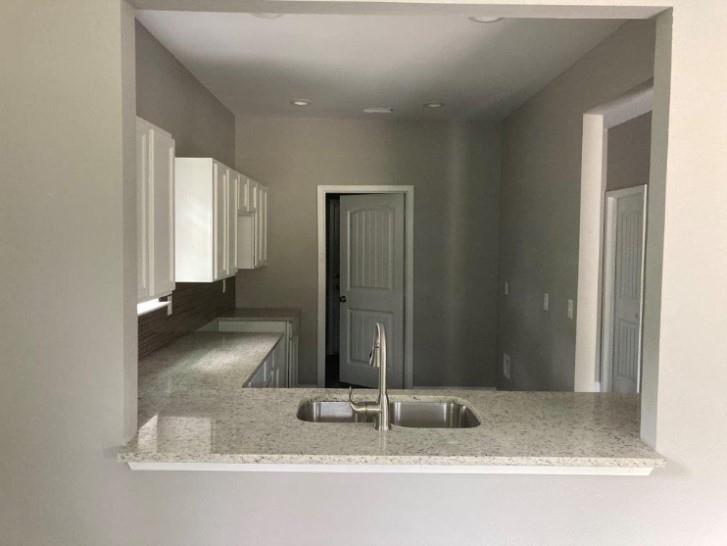 809 South Travis Avenue Denison, TX 75021 - Photo 12 of 13 a bathroom with a granite countertop sink and a mirror