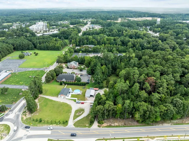 an aerial view of residential houses with outdoor space and trees