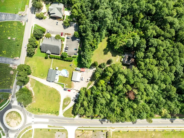 an aerial view of a house with a yard and swimming pool