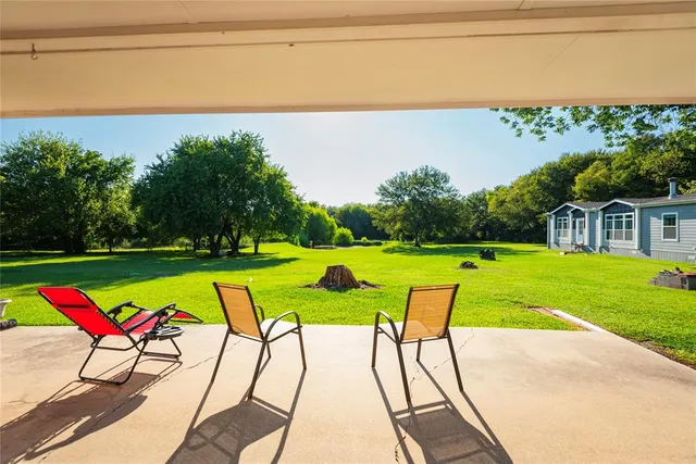 a view of swimming pool with seating space and yard