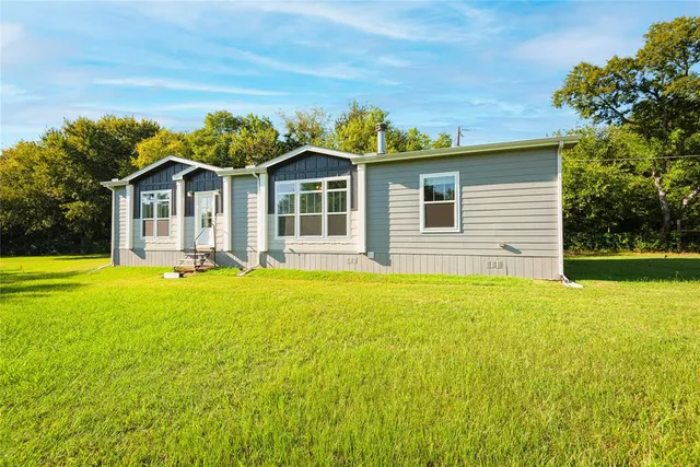 a front view of a house with yard and green space
