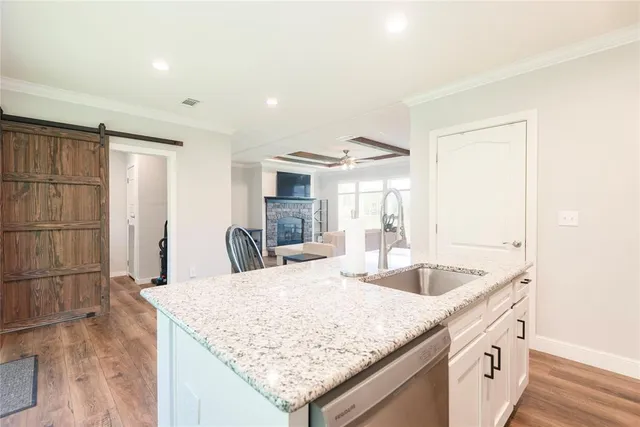 a kitchen with granite countertop kitchen island a sink stove and refrigerator