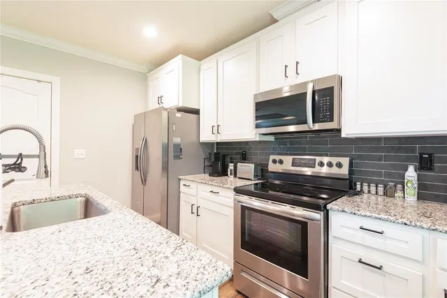 a kitchen with stainless steel appliances a stove microwave and refrigerator