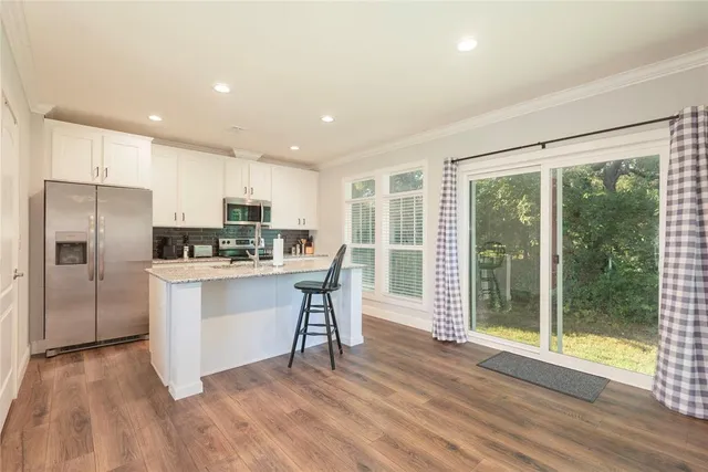 a kitchen with refrigerator cabinets and wooden floor