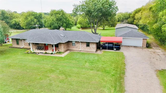 a aerial view of a house with a yard table and chairs
