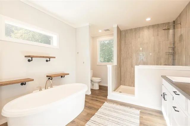 a bathroom with a sink a toilet a mirror and shower