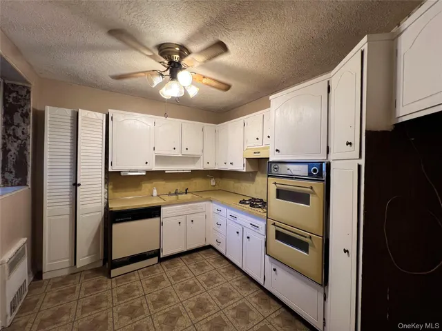 a kitchen with a sink stainless steel appliances and white cabinets