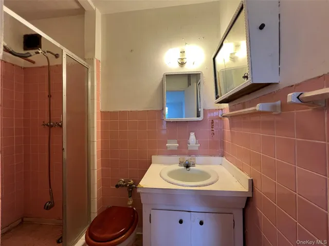 a bathroom with a sink toilet vanity and shower