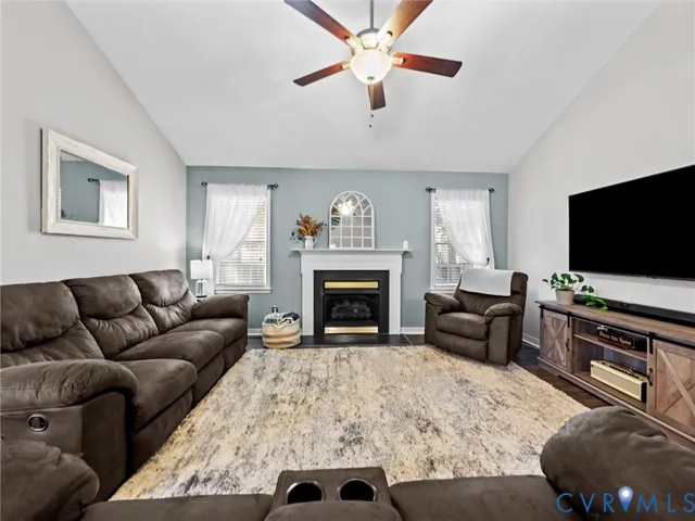 a living room with furniture a flat screen tv and a fireplace