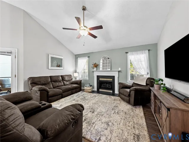 a living room with furniture a flat screen tv and a fireplace