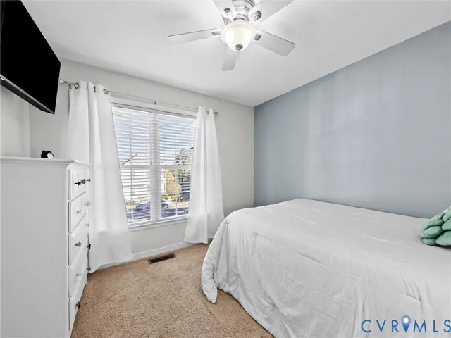 a spacious bedroom with a bed and a flat screen tv