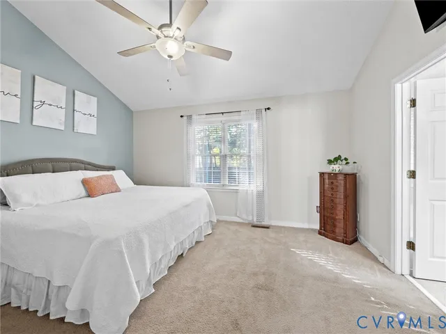 a bedroom with a large bed and a chandelier