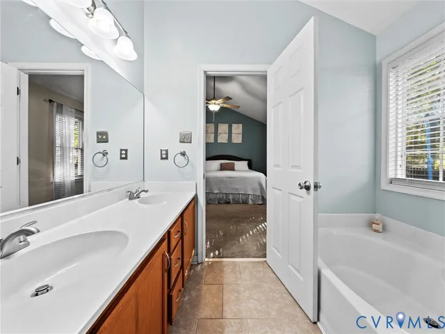 a en suite bathroom with a double vanity sink tub and mirror